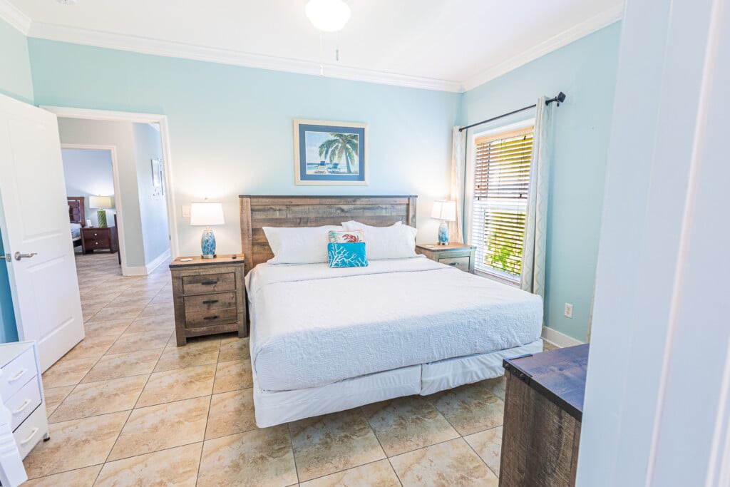 Primary Bedroom - Unwind in your comfortable King Bed, enjoy the privacy of your En-Suite Bathroom, and end the day watching your favorite shows on TV.